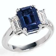 product image of emerald cut sapphire ring with diamond side stones in white metal