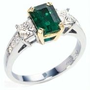 product image of emerald-cut emerald ring with diamond side stones in two-tone metal